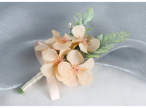 Detail of champagne boutonniere with faux flowers, white pearls and pink silk ribbon