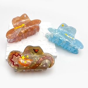 Three acrylic hair claws in orange blue and brown featuring starry sky patterns