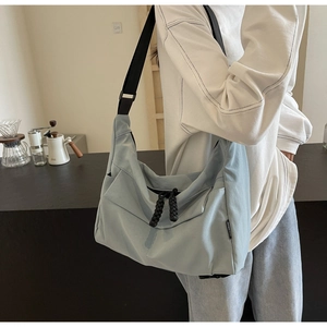 Lifestyle view of light blue large capacity nylon crossbody tote bag worn by a model