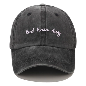 Detailed embroidery of pink Bad Hair Day text on a washed black denim baseball cap