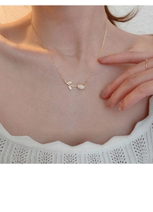 Elegant gold tulip necklace with white chalcedony worn on a neck for style display