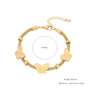Vue détaillée des breloques papillon en acier doré avec dimensions et détails de matière