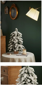 Close-up of artificial flocked snowy Christmas tree with a rustic natural wooden base