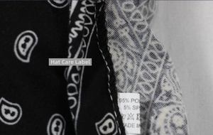Close-up of paisley print headscarf detailing 95% polyester fabric and overlock stitching