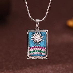 Macro view of silver Tarot The Sun pendant with blue stone and colorful rhinestones