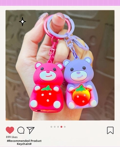 Dettaglio portachiavi a forma di orso luminoso in rosa e viola con fragole illuminate