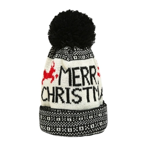 Knit Christmas beanie with black pompom featuring Merry Christmas text and red reindeer