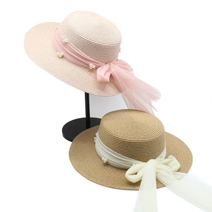 Details von gewebten Strohhüten mit eleganten Chiffonbändern und Perlenverzierungen