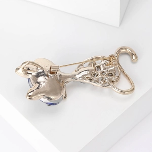 Detailed back view of cat brooch featuring safety pin clasp and gold metal structure