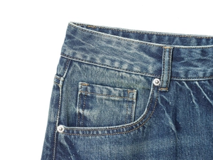 Detailed macro view of light blue denim fabric with precise stitching and metal rivets