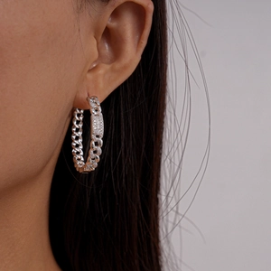 Close-up of a silver chain hoop earring with micro-pave cubic zirconia on a model