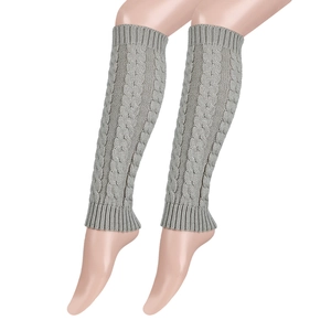 Detail shot of grey cable-knit leg warmers showing thick braided texture on leg model