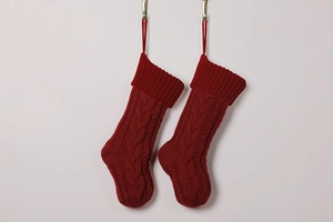 Detail of red cable-knit Christmas stockings with hanging loops on metal hooks