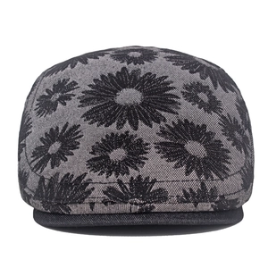 Detailed macro view of black daisy floral jacquard pattern on vintage denim ivy cap