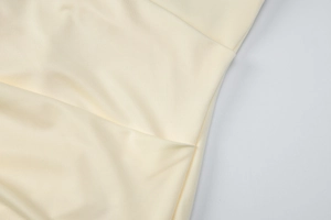 Detailed view of beige halter dress fabric showing premium stitching and ruched texture