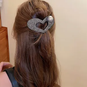 Elegant heart hair claw with sparkling crystals and large pearl on half-up hair