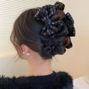 Elegant black lace bow hair clip with sequins shown on model's back hair view