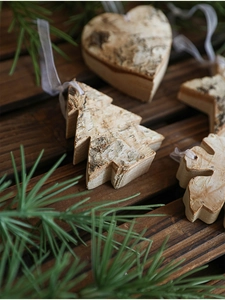 Detail view of natural birch bark Christmas ornaments in tree, heart, and snowflake shapes