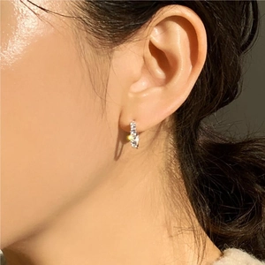 Close-up of minimalist 925 sterling silver hoop earrings with pavé zircon stones on a model