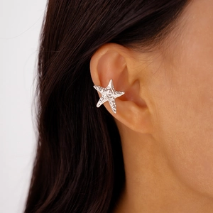 Close-up of a silver starfish ear cuff with textured metal finish on model's ear