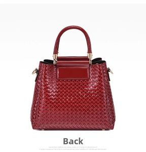 Detailed back view of burgundy woven leather handbag with glossy finish and gold hardware