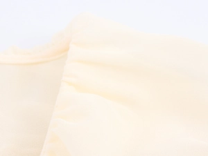 Detailed macro shot of pale yellow chiffon dress fabric with elegant pleated ruffles