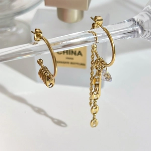 Asymmetric gold tassel earrings with spiral design and sparkling crystal pendant details