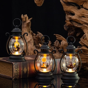 Three black Halloween LED lanterns with glowing castle silhouettes on a wooden background
