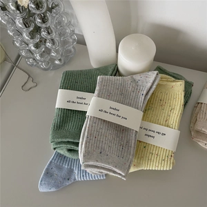 Mid-calf cotton socks in green, grey, yellow, and blue with colorful nep yarn texture