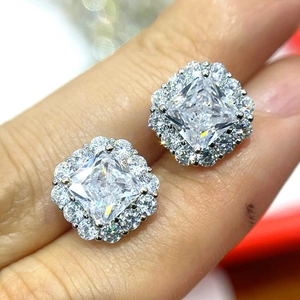Macro view of square princess cut halo stud earrings with brilliant faux diamonds