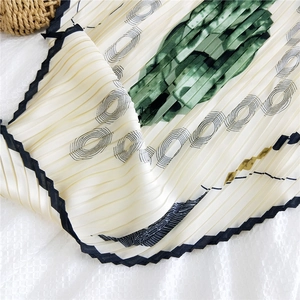 Foulard in seta plissettata con motivi geometrici verdi su sfondo beige chic
