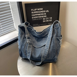 Vue latérale du sac cabas en jean bleu avec poches latérales et boucle métallique réglable