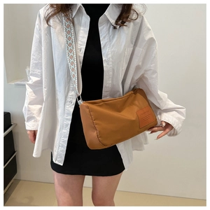 Brown oxford boston bag with geometric wide shoulder strap shown on a model