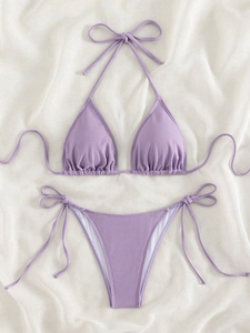Flat lay of lavender ribbed bikini set featuring halter top and side-tie bottom