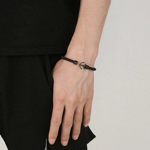 Detailed shot of black woven steel mesh bracelet with anchor clasp on male wrist