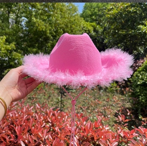 Detalle de sombrero vaquero rosa con borde de plumas suaves y cordón ajustable para la barbilla
