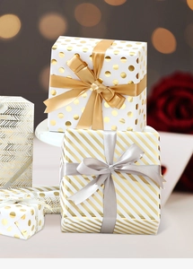 Detailed view of gold foil stripe gift wrapping paper with a luxury satin ribbon