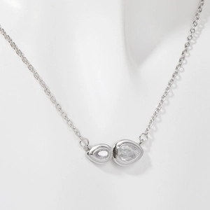 Detail of silver double teardrop pendant necklace with clear zircon stones on a model