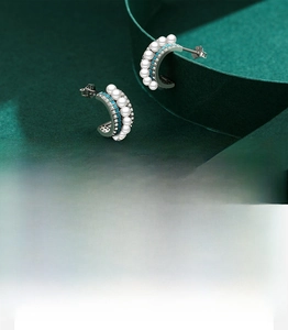 Détail macro de boucles d'oreilles C en argent S925 avec turquoise, perles et zircons