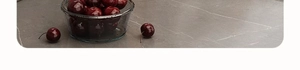 Detail of wall-mounted kitchen rack holding a glass bowl of fresh red cherries