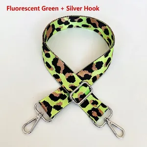 Macro shot of neon green leopard print nylon strap with adjustable silver metal hooks