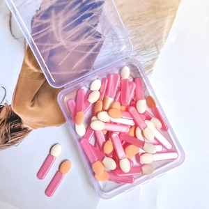 Macro view of double-sided sponge eyeshadow applicators neatly organized in a clear storage box