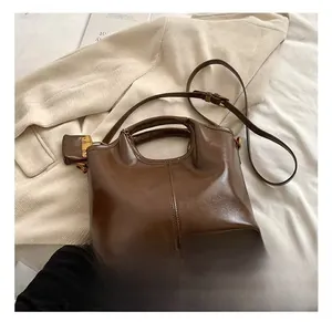 Detailed view of dark brown vintage oil-wax leather tote bag with slim shoulder strap
