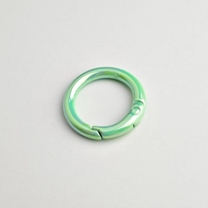 Detail of round spring gate ring in gradient light green iridescent alloy finish