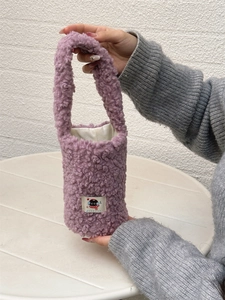 Macro view of purple plush cup holder bag with soft texture and cartoon cat patch