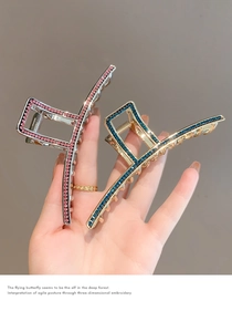 Close-up of elegant gold and silver hair claws with sparkling blue and pink rhinestones