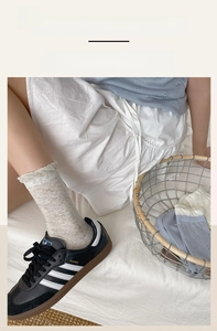Detail of high-elasticity ruffled cuffs on cotton bow socks in grey and light blue
