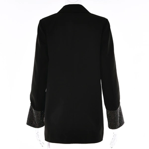 Vista posteriore del blazer nero con dettagli in strass sulle maniche e taglio sartoriale