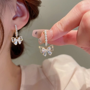 Orecchini a cerchio a fiocco dorati con perle bianche e zirconi brillanti da donna