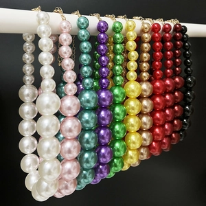 Close-up showing a variety of colorful gradient pearl necklaces on display stands